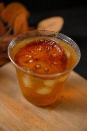 桌面上的杯子里的甘甜可口的冰木橘茶