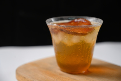 桌面上的杯子里的甘甜可口的冰木橘茶