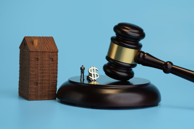 蓝色背景下拍卖锤傍边的房子和资金模型创意