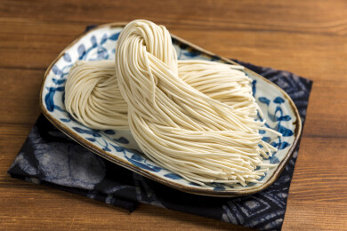 一盘生面条摆放在桌面上特写