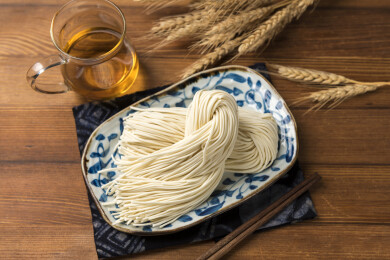 一盘生面条摆放在桌面上特写
