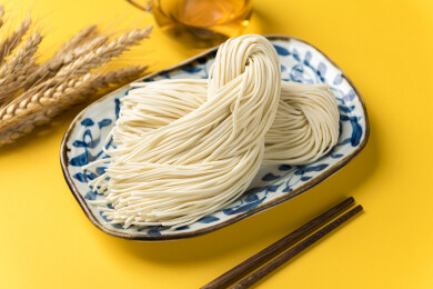 一盘生面条摆放在桌面上特写