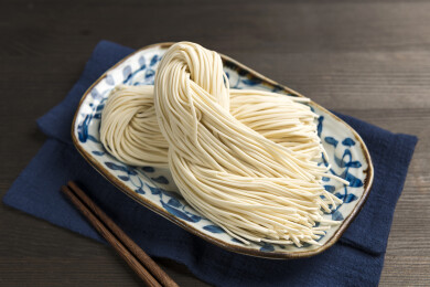 一盘生面条摆放在桌面上特写