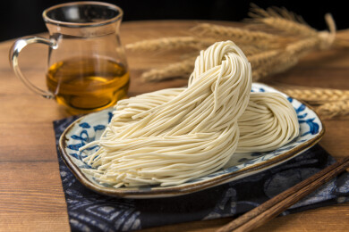 一盘生面条摆放在桌面上特写