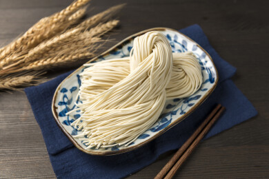 一盘生面条摆放在桌面上特写