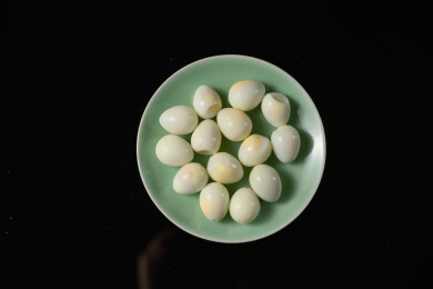 桌面上的盘子里的美味可口的水煮鹌鹑蛋