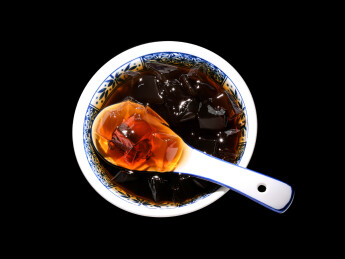 黑色背景上的一碗广东特色糖水凉粉龟苓膏