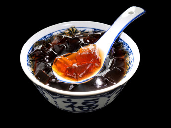 黑色背景上的一碗广东特色糖水凉粉龟苓膏