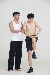 年轻男子在教练的指导下健身