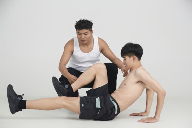 年轻男子在教练的指导下健身