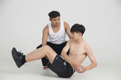 年轻男子在教练的指导下健身