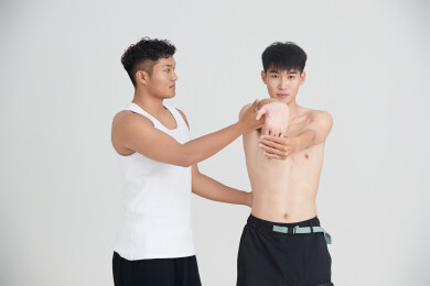 年轻男子在教练的指导下健身