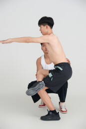 年轻男子在教练的指导下健身