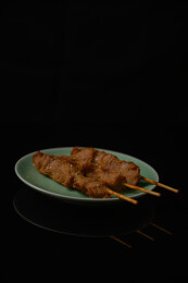 桌面上的盘子里的美味可口的炸猪肉串