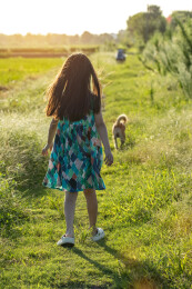 亚洲小女孩带着小狗在户外的背影