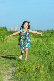 乡村草地上奔跑的亚洲小女孩
