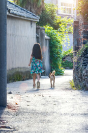 亚洲小女孩带着小狗在户外的背影