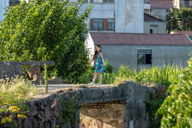 站在乡村小桥上的亚洲小女孩