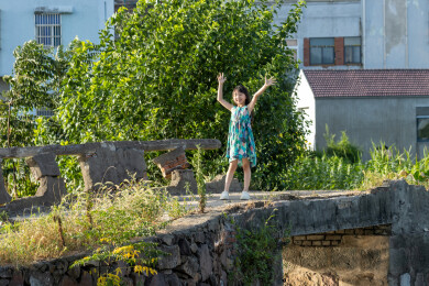 站在乡村小桥上的亚洲小女孩