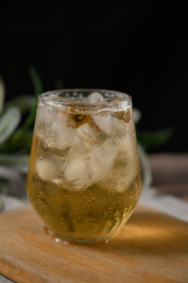 桌面上的杯子里的甘甜可口的冰茶花花茶