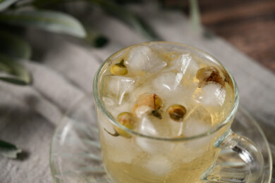 桌面上的杯子里的甘甜可口的冰茶花花茶