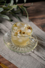 桌面上的杯子里的甘甜可口的冰茶花花茶