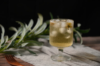桌面上的杯子里的甘甜可口的冰茶花花茶