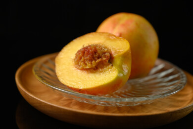 桌面上的盘子里的美味可口的切半黄桃