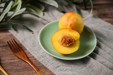 桌面上的盘子里的美味可口的切半黄桃