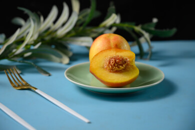 桌面上的盘子里的美味可口的切半黄桃