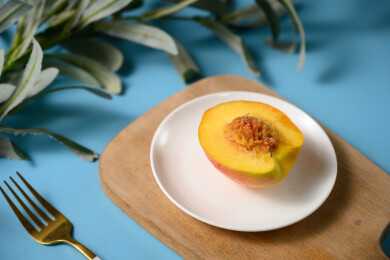 桌面上的盘子里的美味可口的切半黄桃