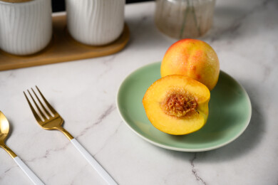 桌面上的盘子里的美味可口的切半黄桃