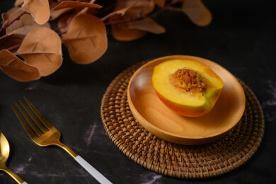 桌面上的盘子里的美味可口的切半黄桃