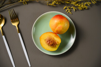 桌面上的盘子里的美味可口的切半黄桃