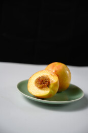 桌面上的盘子里的美味可口的切半黄桃