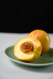 桌面上的盘子里的美味可口的切半黄桃