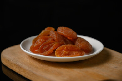 桌面上的盘子里的美味可口的红杏干