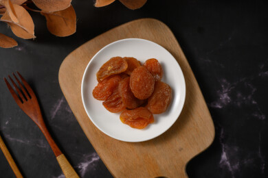 桌面上的盘子里的美味可口的红杏干