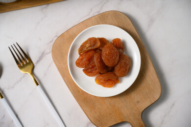 桌面上的盘子里的美味可口的红杏干