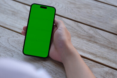 手拿着绿色屏幕的智能手机