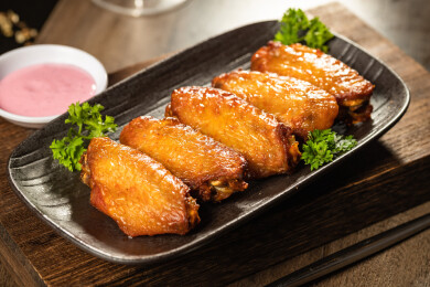 棕色木纹桌上有一份烤鸡翅