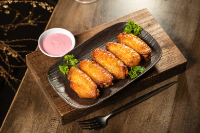 棕色木纹桌上有一份烤鸡翅