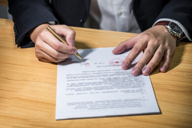 商人用手在发票、贷款、汽车租赁等文件签字