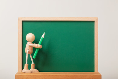 微缩创意留白黑板与拿笔的木头人