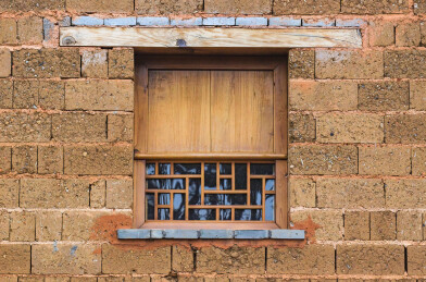 云南古村落土坯房墙的老式木雕窗子