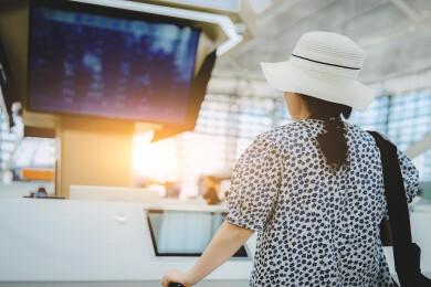 女旅客在明亮的晨光下办理登机手续