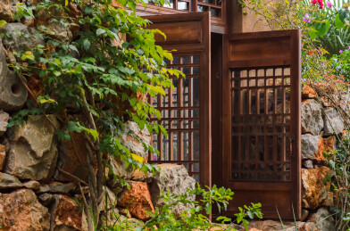 老房子土墙上打开的老式木雕窗子