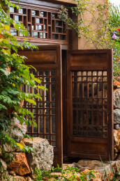 老房子土墙上打开的老式木雕窗子