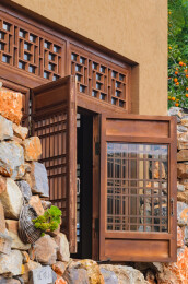 老房子土墙上打开的老式木雕窗子