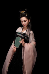 手持轻扇展示唐代服饰妆容造型的东方女性